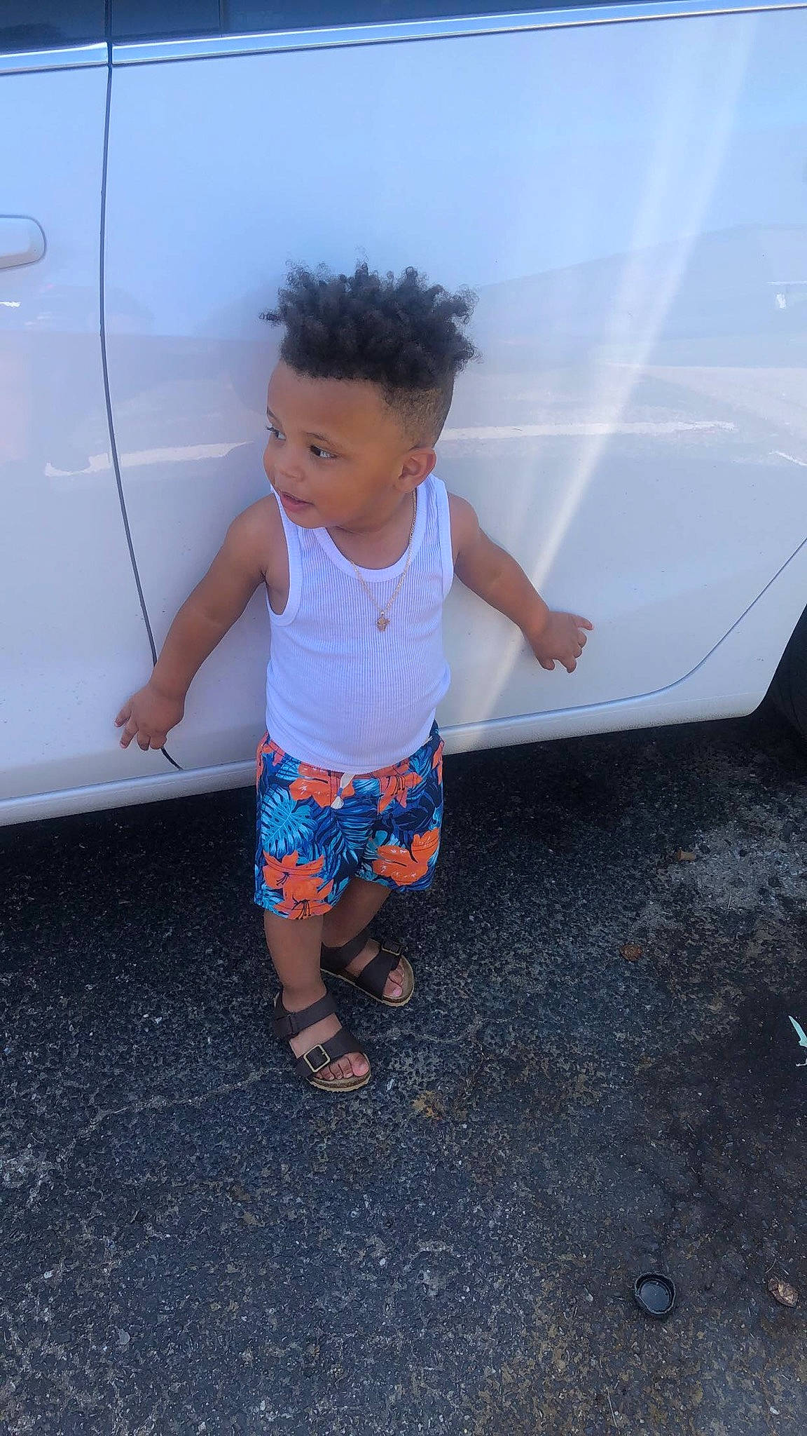 Kace is registered to the contest to win money with this photo: asphalt, automotive_design, automotive_exterior, automotive_lighting, automotive_tire, baby_toddler_clothing, bumper, car, child, electric_blue, happy, hood, motor_vehicle, person, shorts, standing, t_shirt, tints_and_shades, toddler, trunk