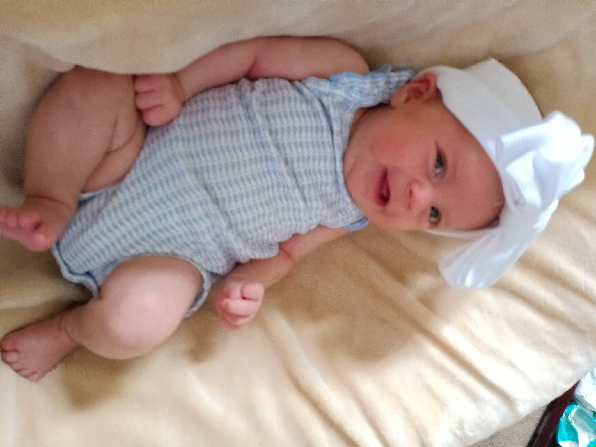 Armani is registered to the contest to win money with this photo: baby, baby_toddler_clothing, child, comfort, finger, foot, hand, hat, headwear, iris, linens, nail, pattern, person, room, skin, sleeve, thumb, toddler