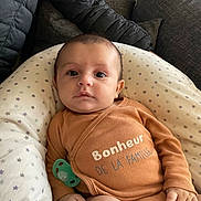 Maylan participe au concours pour gagner de l'argent avec cette photo : baby, child, clothing, comfortable, cozy, cushion, cute, expression, face, hand, indoor, infant, leg, onesie, pacifier, person, portrait, seated, soft_fabric, star_pattern