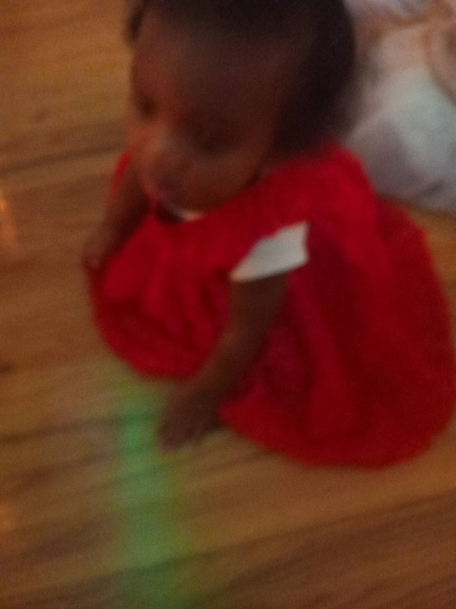 Melanie is registered to the contest to win money with this photo: baby, baby_toddler_clothing, carmine, cheek, child, floor, flooring, fun, fur, hardwood, nose, person, room, sitting, sleeve, thumb, toddler, under_exposed, varnish, wood