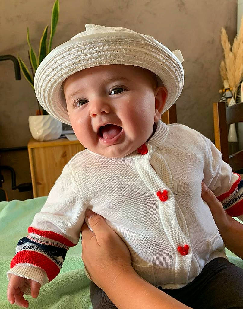 Amalia a rejoint le concours — aidez-le/la à gagner de superbes lots ! baby, baby_toddler_clothing, cap, cheek, child, comfort, fedora, happy, hat, headgear, headwear, houseplant, human_body, lip, mouth, person, sitting, skin, sleeve, smile