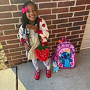 Chozyn joined the competition — help win amazing prizes! child, girl, brick_wall, backpack, cartoon_character, toy, red_shoes, white_tights, strawberry_pattern, hair_beads, pink_bow, sidewalk, outdoor, smiling, posing, clothing, accessory, happy, person, casual