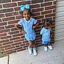 child, children, girl, boy, blue_clothing, bow, braids, pacifier, sneakers, brick_wall, sidewalk, outdoor, happy, smile, posing, cute, standing, portrait, siblings, playful
