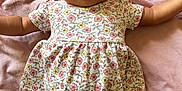 Diyonne is registered to the contest to win money with this photo: baby, infant, child, pink_bow, headband, floral_dress, blanket, soft_fabric, lying_down, cute, wide_eyes, outstretched_arms, portrait, smiling, happy, indoors, one_person, close_up, skin, face