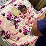 arm, baby, blanket, chair, curtain, cute, fabric, heart_pattern, hello_world, indoors, infant, minnie_mouse, newborn, person, pink_clothing, plaque, sleeping, soft_texture, table, wood_floor