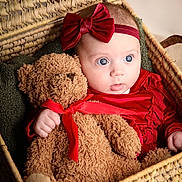 Luna participe au concours pour gagner de l'argent avec cette photo : baby, teddy_bear, red_bow, red_outfit, basket, woven_basket, plush_toy, child, cute, portrait, indoor, cuddling, soft_toy, infant, headband, hand, expression, cozy, warm_lighting, closeup