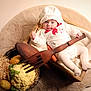 baby, basket, blanket, carrot, cauliflower, closeup, cozy, hat, infant, newborn, plush_rug, portrait, potatoes, props, straw, studio_lighting, tights, vegetables, white_clothing, wooden_fork