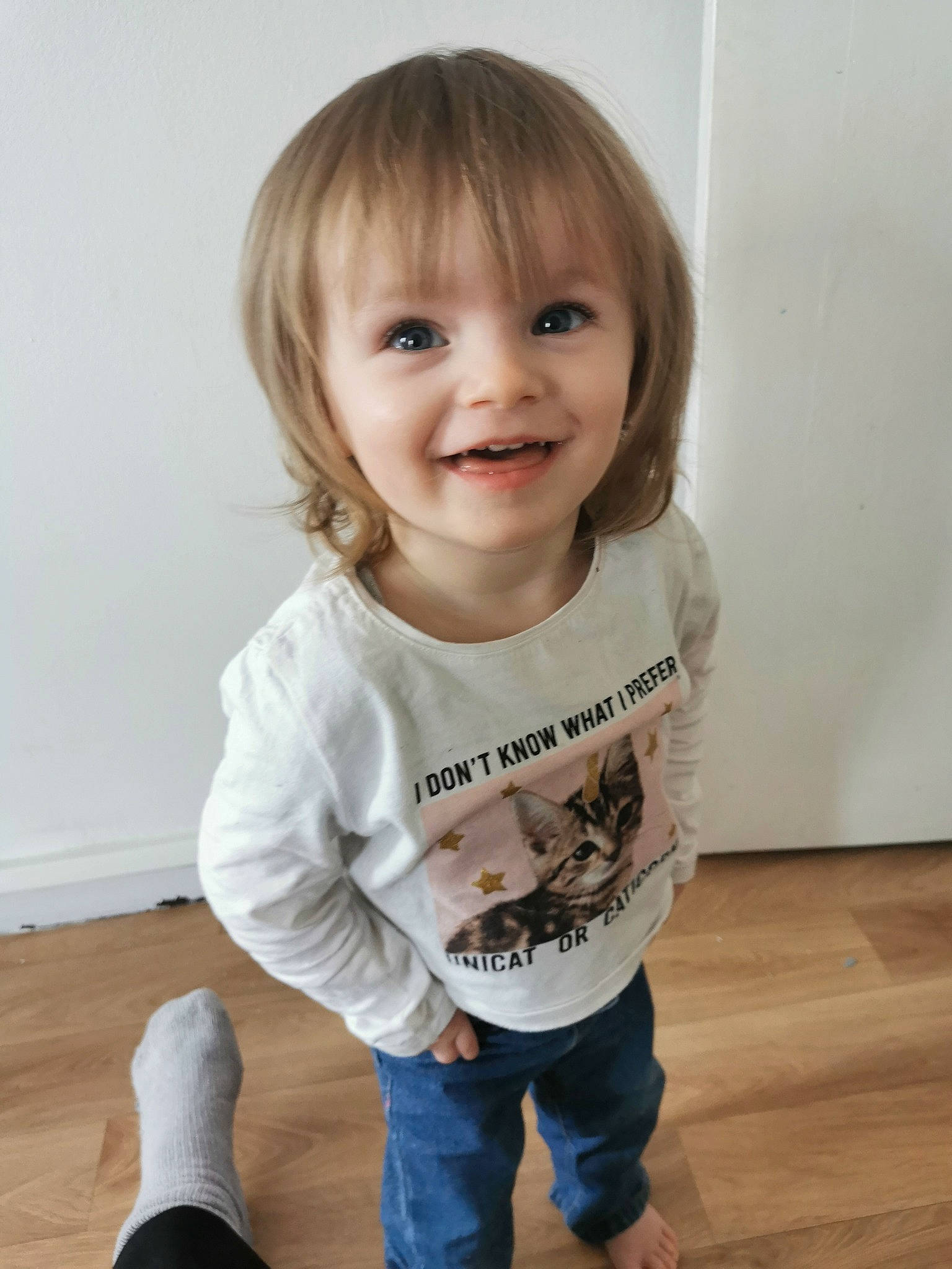 Océane a rejoint le concours — aidez-le/la à gagner de superbes lots ! baby_toddler_clothing, cheek, denim, eye, floor, flooring, happy, hardwood, iris, jeans, joint, joy, knee, person, sitting, skin, sleeve, smile, standing, t_shirt