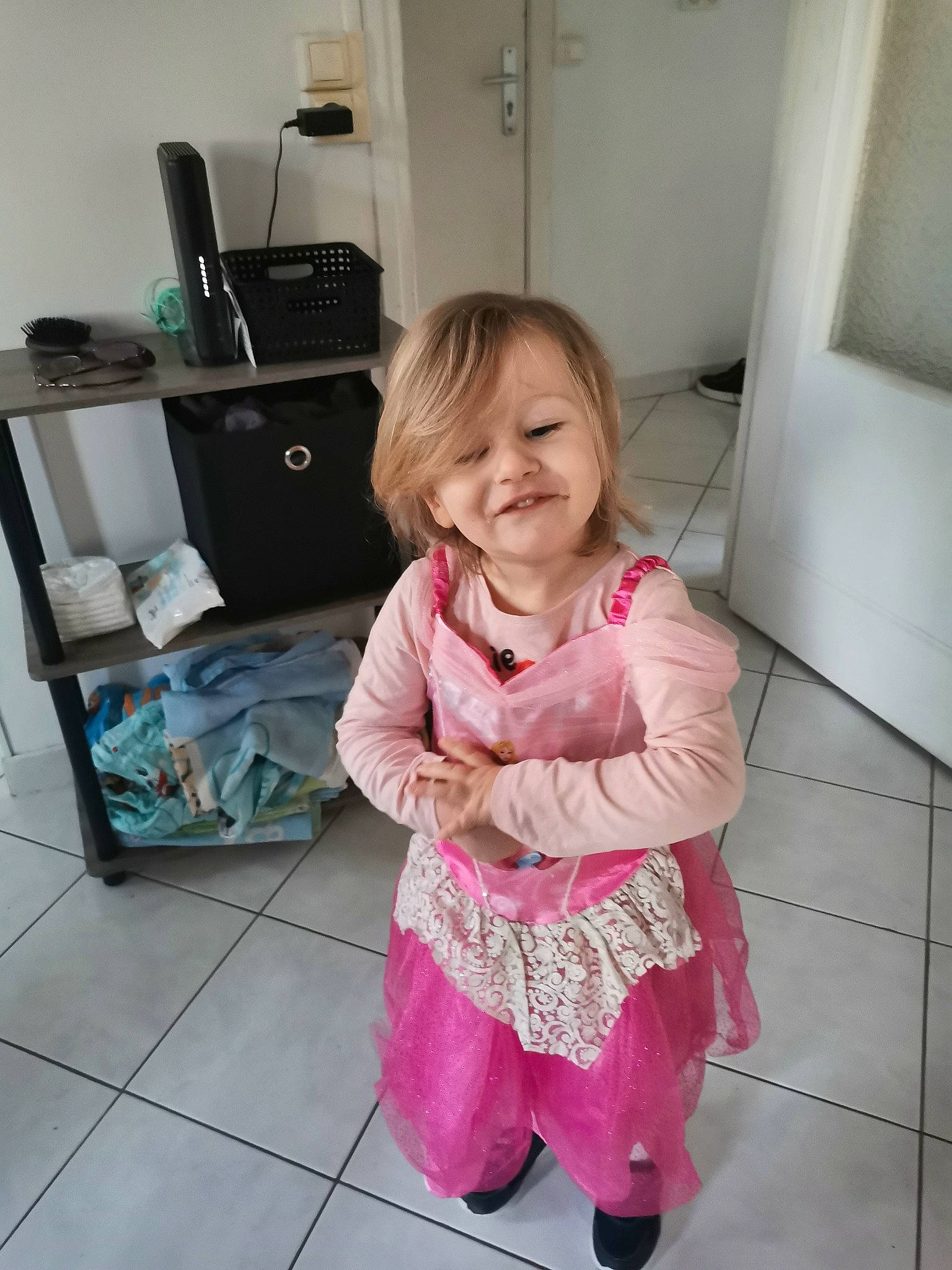 Célia a rejoint le concours — aidez-le/la à gagner de superbes lots ! baby_toddler_clothing, bag, cabinetry, child, drawer, floor, flooring, fun, happy, hardwood, human_leg, joy, luggage_and_bags, magenta, pattern, person, pink, room, sitting, sleeve