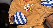 Makaio is registered to the contest to win money with this photo: baby, brown, child, closed_eyes, clothing, cozy, cute, face, gap, hands, indoor, infant, mittens, newborn, person, portrait, sleeping, soft, striped, warm