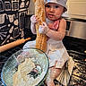 Luxana joined the competition — help win amazing prizes! baby, child, chef_hat, apron, flour, bread, kitchen, stove, mixing_bowl, whisk, baking, cooking, messy, cute, portrait, indoors, food_preparation, playful, person, cooking_utensils