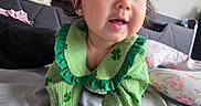 Luxana joined the competition — help win amazing prizes! baby, child, crawling, green_clothing, clover, bed, pillow, indoor, person, cute, happy, face, hands, skin, hair, room, furniture, blanket, curious, smiling