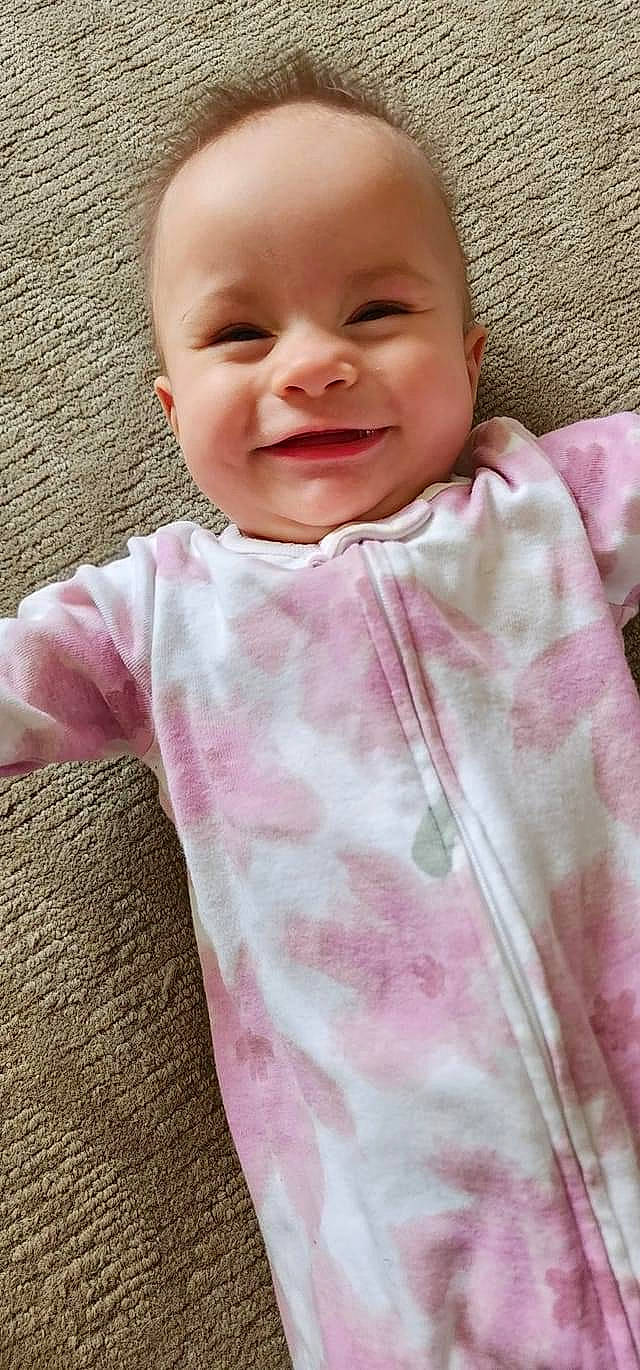 Korra is registered to the contest to win money with this photo: baby, baby_toddler_clothing, cheek, child, collar, comfort, eye, face, happy, head, joy, linens, lip, magenta, pattern, person, pink, skin, sleeve, smile