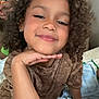 Truu joined the competition — help win amazing prizes! child, curly_hair, smile, indoor, person, face, hand, brown_shirt, relaxed, portrait, casual, happy, kid, young, curly, skin, earrings, seated, cozy, home