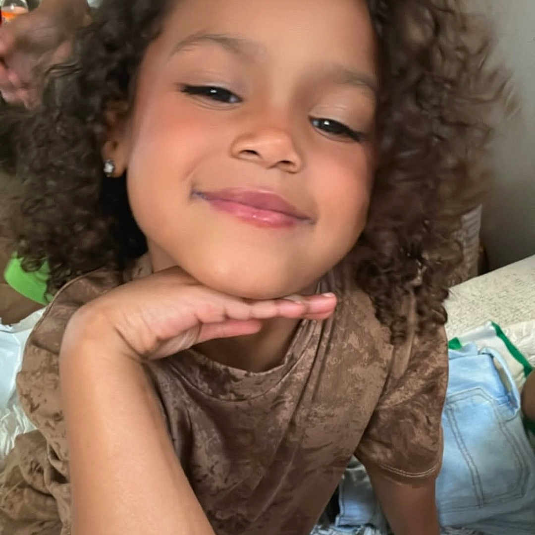 Truu joined the competition — help win amazing prizes! brown_shirt, casual, child, cozy, curly, curly_hair, earrings, face, hand, happy, home, indoor, kid, person, portrait, relaxed, seated, skin, smile, young
