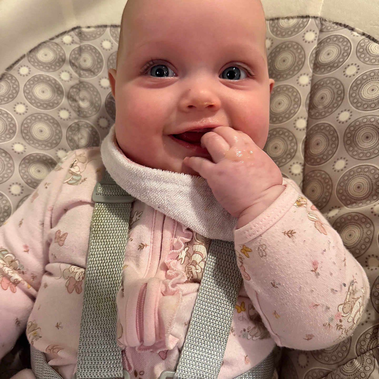 Meredith joined the competition — help win amazing prizes! baby, infant, child, high_chair, seatbelt, pink_clothing, patterned_fabric, hand_in_mouth, smile, happy, face, blue_eyes, cute, indoor, portrait, closeup, baby_girl, soft_lighting, cozy, sitting