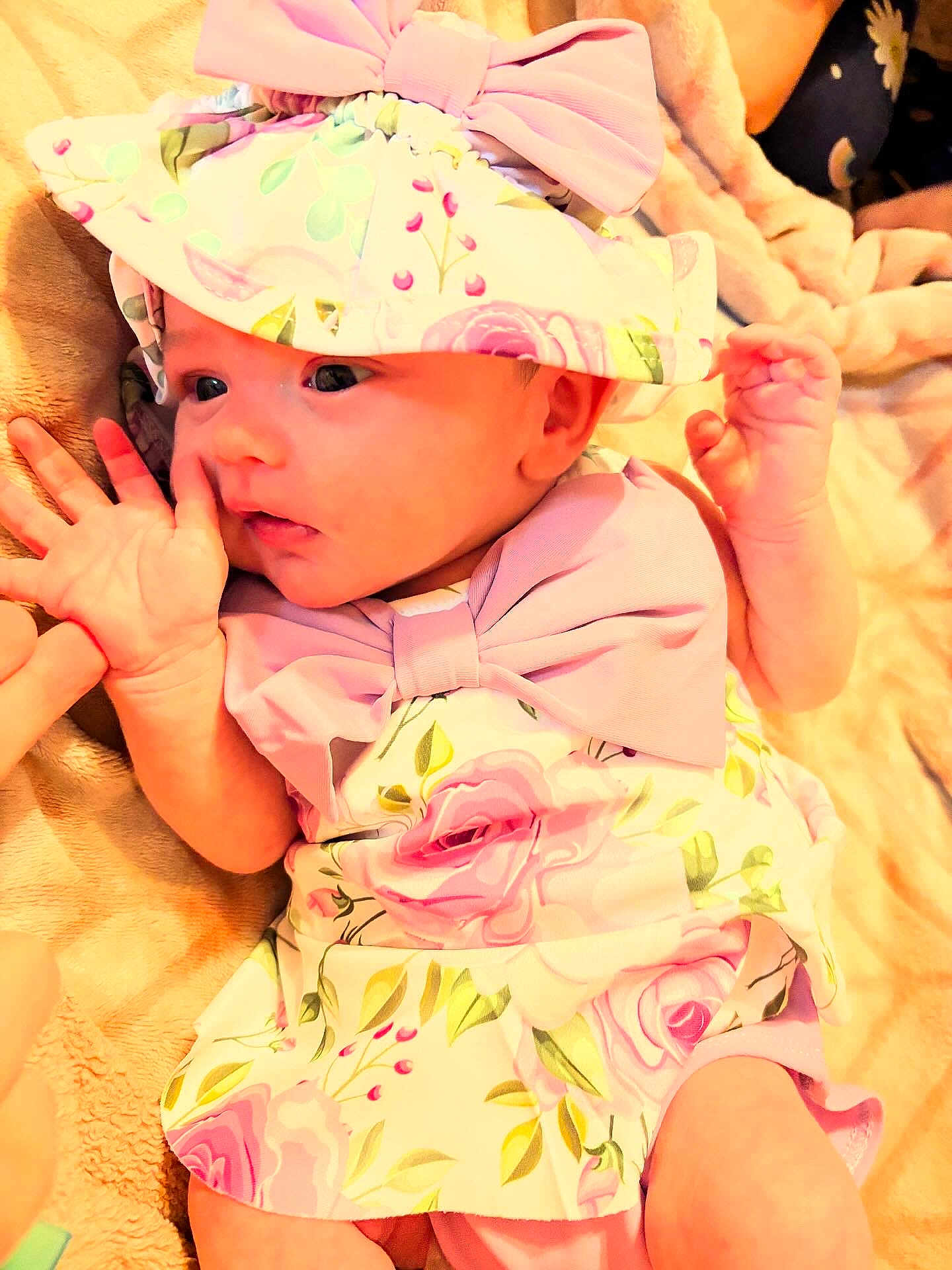 Lilly Rose Pfaff joined the competition — help win amazing prizes! baby, infant, hat, bow, floral_pattern, clothing, hand, finger, blanket, soft_texture, cute, portrait, newborn, pink, skin, face, eyes, expression, lying_down, person