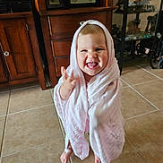 Freya joined the competition — help win amazing prizes! toddler, child, blanket, pink, smiling, happy, indoor, tile_floor, barefoot, cabinet, furniture, home, portrait, cute, wrapped, young_child, expression, joyful, face, standing