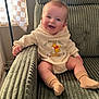 baby, child, smile, hoodie, winnie_the_pooh, socks, armchair, green, indoor, window, curtain, happy, cute, person, portrait, seated, clothing, soft_lighting, cozy, infant