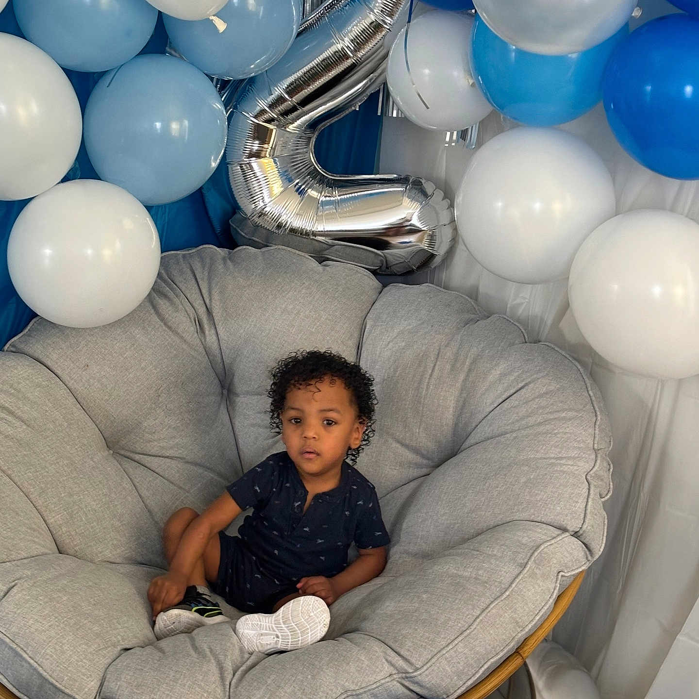 Rylan joined the competition — help win amazing prizes! balloons, birthday, blue, casual_clothing, celebration, chair, child, comfortable, curly_hair, cushion, decorations, happy, indoor, number_two, party, person, shoes, silver, smiling, white
