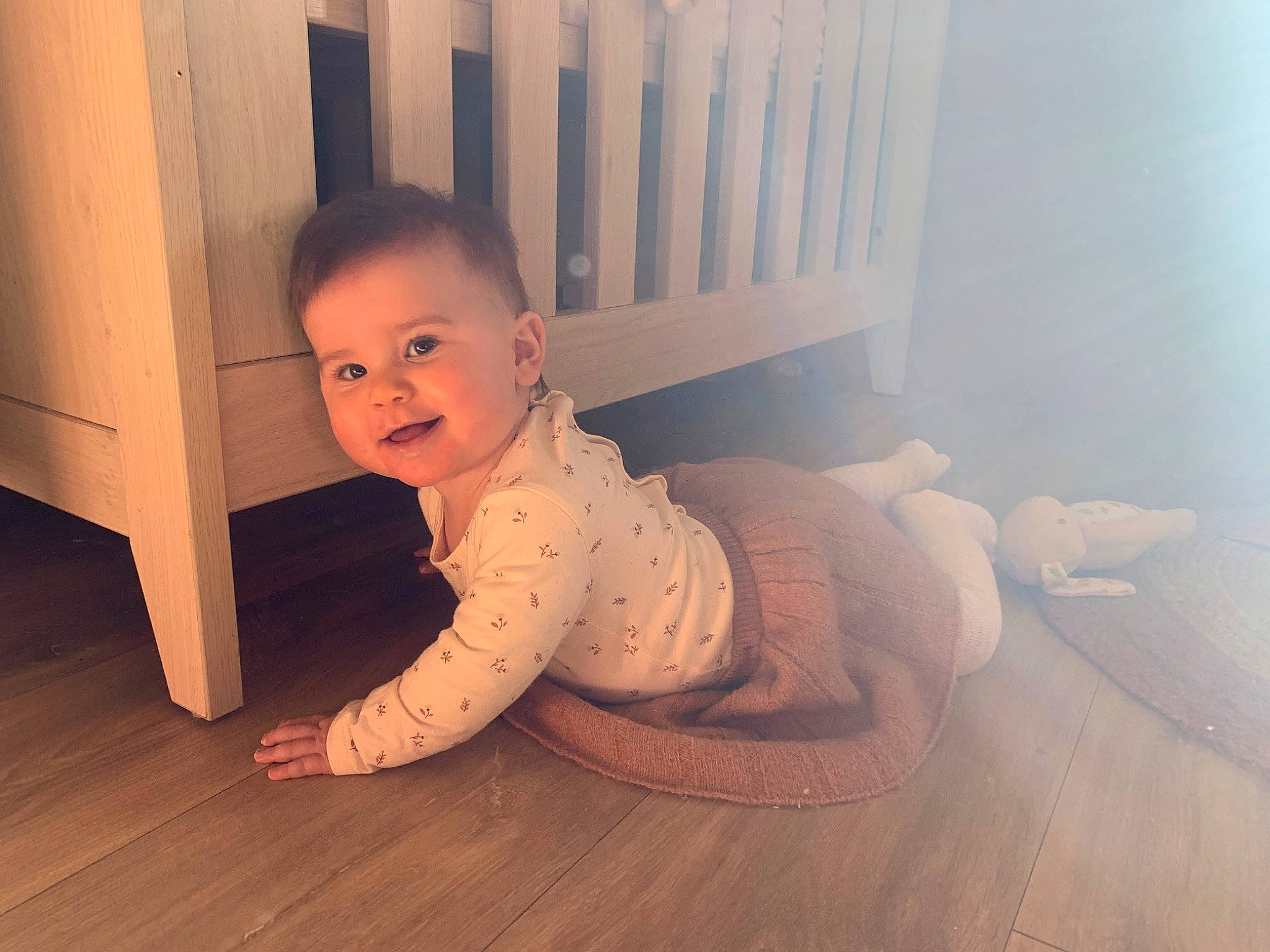 Julia a rejoint le concours — aidez-le/la à gagner de superbes lots ! baby, baby_toddler_clothing, child, comfort, crawling, floor, flooring, foot, happy, hardwood, human_leg, laminate_flooring, pattern, person, sitting, smile, toddler, varnish, wood, wood_flooring