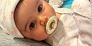 Anya joined the competition — help win amazing prizes! baby, closeup, comfort, cozy, cushion, eyes, face, gray, hat, indoor, infant, pacifier, pajamas, pattern, person, pink, resting, soft, white, young_child