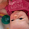 Melody is registered to the contest to win money with this photo: baby, infant, newborn, child, portrait, upside_down, pink_clothing, onesie, blanket, pacifier, play_mat, lying_down, indoors, close_up, face, eyes, head, cozy, colorful, textile