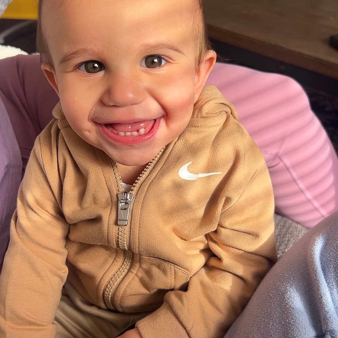 Adam joined the competition — help win amazing prizes! candid, casual, child, clothing, cozy, expression, eyes, face, hand, happy, hoodie, indoor, light_shadow, person, portrait, remote_control, seated, smiling, toddler, young