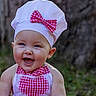 baby, child, portrait, smiling, laughing, outdoor, chef_hat, bow_tie, apron, gingham, red_and_white, heart, face, blue_eyes, happy, infant, close_up, nature, greenery, photography