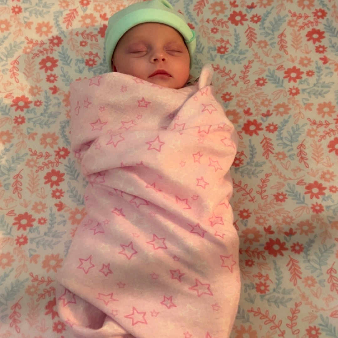 Isabella is registered to the contest to win money with this photo: baby, bed, blanket, bonnet, cap, clothing, face, furniture, glove, hat, head, hood, newborn, person, photography, portrait, purple, quilt, sleeping, towel