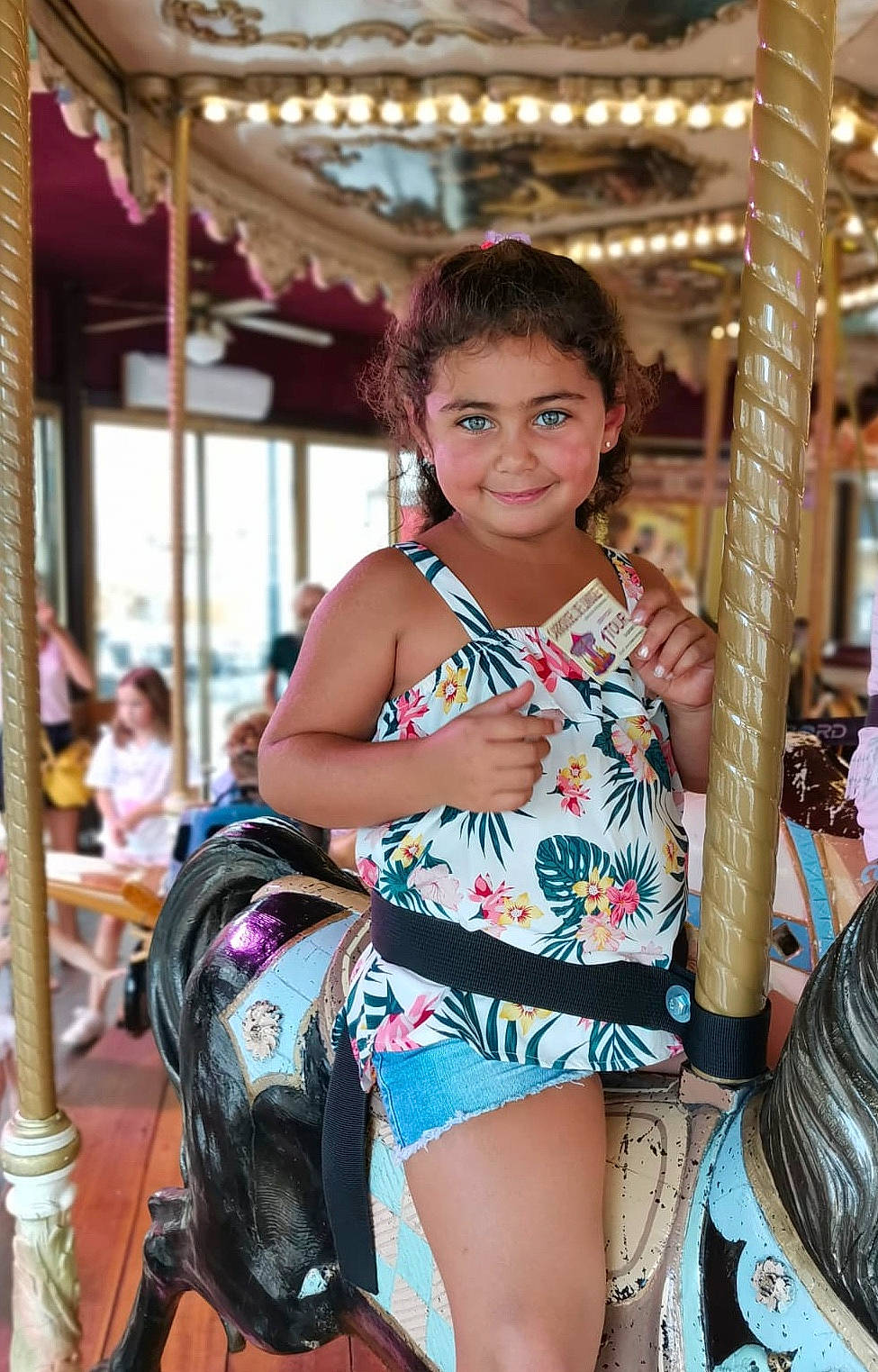 Lou-ann participe au concours pour gagner de l'argent avec cette photo : amusement_park, black_hair, brown_hair, carousel, child, event, face, fashion_design, fun, happy, human_leg, jewellery, joy, leisure, long_hair, neck, person, recreation, smile, street_fashion