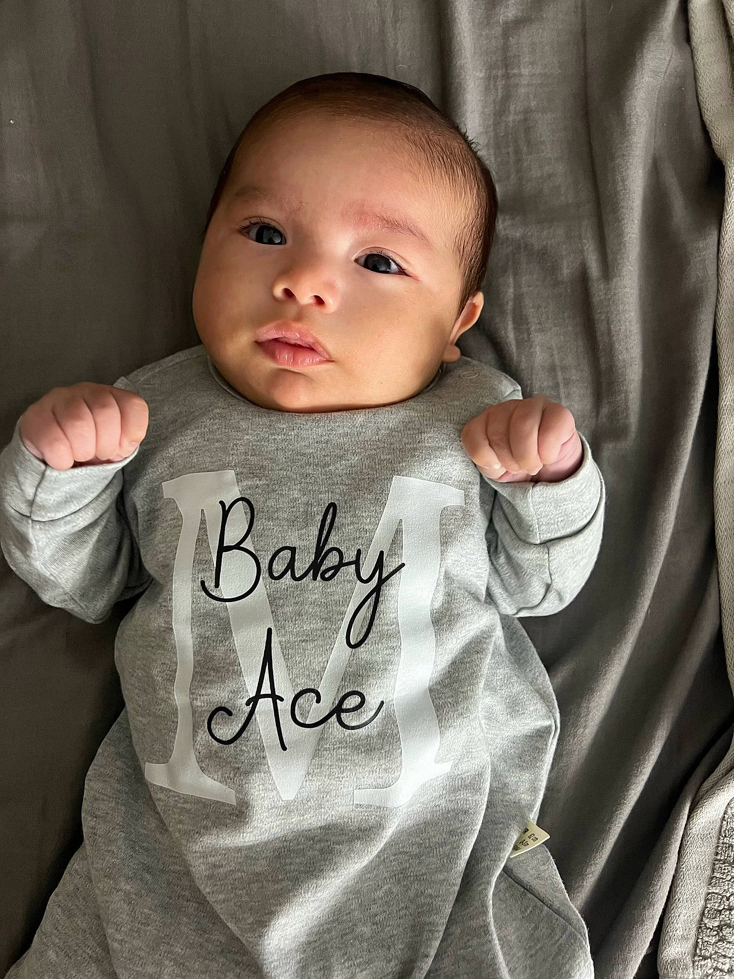 Ace is registered to the contest to win money with this photo: baby, baby_toddler_clothing, cheek, chin, eyebrow, face, facial_expression, finger, flash_photography, gesture, grey, hand, happy, head, lip, neck, outerwear, person, skin, sleeve