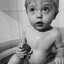 Olan a rejoint le concours — aidez-le/la à gagner de superbes lots ! child, toddler, bath, toy, inflatable_tub, water, naked, skin, face, eyes, hand, curious, expression, indoor, tile_wall, monochrome, black_and_white, bathroom, young, cute