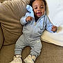Joshua is registered to the contest to win money with this photo: baby, child, smiling, couch, clothing, footwear, nike, tracksuit, hoodie, sitting, happy, infant, indoor, person, cute, young, small, cozy, comfortable, portrait