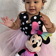 Rosalia is registered to the contest to win money with this photo: baby, toddler, child, polka_dot, black_dress, pink_tutu, plush_toy, minnie_mouse, stuffed_animal, bracelet, curly_hair, smile, portrait, indoor, blanket, happy, sitting, hands, bow, cute