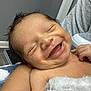 Raul is registered to the contest to win money with this photo: baby, smiling, infant, blanket, arm, tattoo, person, skin, happy, indoors, face, closeup, newborn, resting, cozy, child, human, comfort, expression, portrait