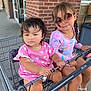 Xiomara joined the competition — help win amazing prizes! child, children, shopping_cart, pink_clothing, sunglasses, outdoor, store, brick_wall, concrete, footwear, braids, handrail, person, cute, summer, playing, toddler, girl, sibling, daylight