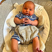 Tobias is registered to the contest to win money with this photo: baby, infant, baby_seat, blue_clothing, striped_clothing, bare_feet, hands_clasped, plush_toy, bear_design, cozy, indoor, cute, chubby_cheeks, portrait, child, young_baby, comfortable, soft_texture, seated, looking_at_camera