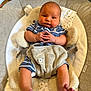 baby, infant, baby_seat, blue_clothing, striped_clothing, bare_feet, hands_clasped, plush_toy, bear_design, cozy, indoor, cute, chubby_cheeks, portrait, child, young_baby, comfortable, soft_texture, seated, looking_at_camera