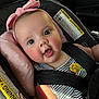 baby, car_interior, car_seat, child, closeup, cute, face, happy, headband, indoors, infant, person, pink, rosy_cheeks, safety, seatbelt, smile, striped_clothing, transportation, yellow_flower