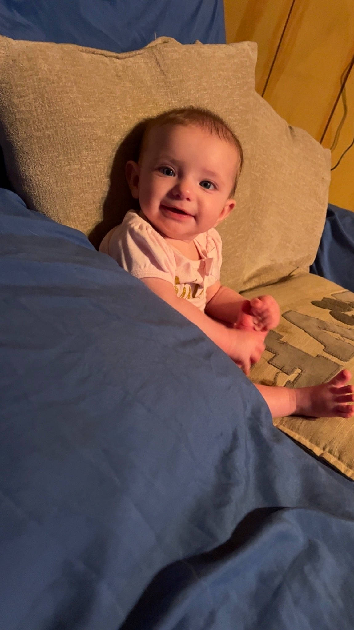 Lydia is registered to the contest to win money with this photo: baby, baby_toddler_clothing, bedding, cheek, child, comfort, couch, face, finger, fun, happy, head, linens, mouth, person, pillow, skin, smile, thumb, toddler