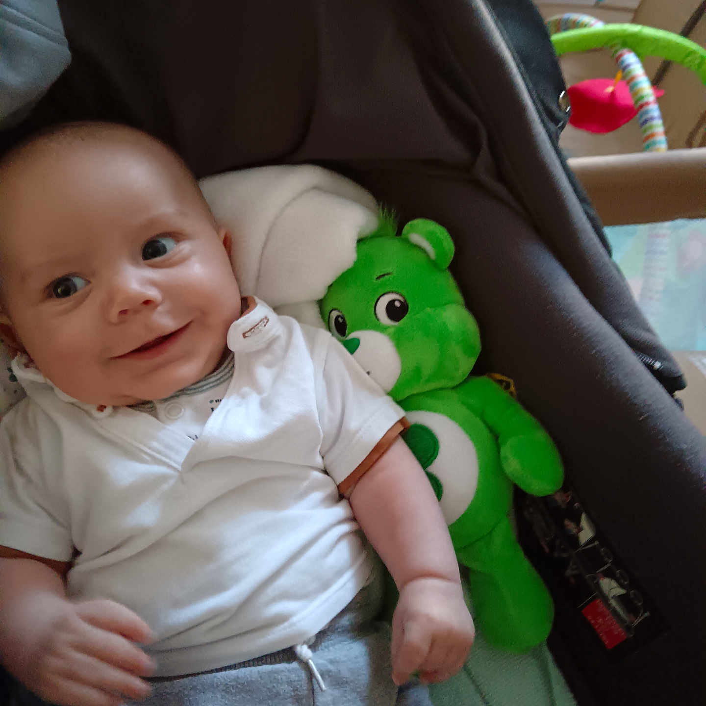 Nolan participe au concours pour gagner de l'argent avec cette photo : baby, blanket, child, clothing, comfort, cute, face, gray_pants, happy, head, indoor, infant, person, playful, smile, soft_toy, stroller, teddy_bear, toy, white_shirt