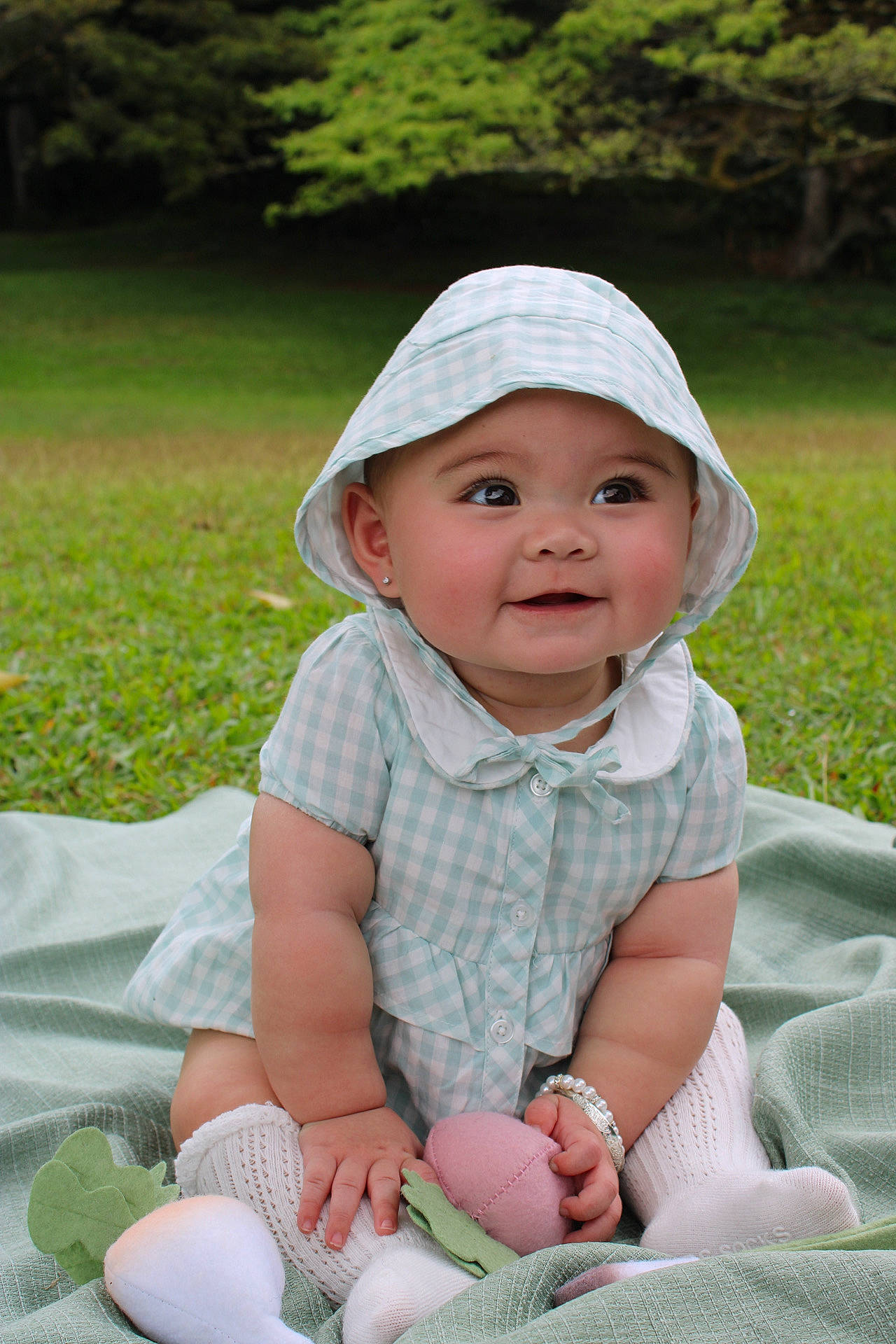 Laila is registered to the contest to win money with this photo: baby, baby_toddler_clothing, cap, child, fun, grass, happy, headwear, leaf, leisure, people_in_nature, person, photograph, pink, plant, recreation, sitting, skin, sleeve, smile