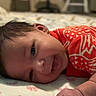 Tylyza joined the competition — help win amazing prizes! baby, infant, smiling, red_clothing, blanket, pink_bows, face, hand, lying_down, indoors, furniture, chair, blurred_background, person, cute, newborn, portrait, soft_lighting, happy, child