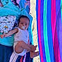 baby, pacifier, towel, blanket, sand, beach, infant, child, sunlight, colorful, striped_towel, clothing, relaxing, outdoor, summer, barefoot, lying_down, cute, resting, playful