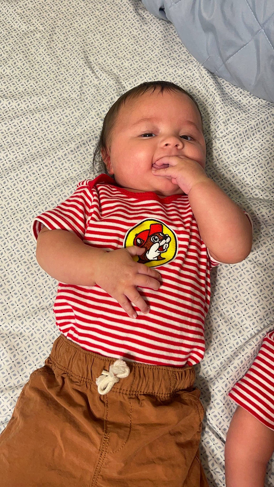 Jaxon is registered to the contest to win money with this photo: baby, baby_products, baby_toddler_clothing, cheek, child, collar, comfort, finger, happy, linens, nose, orange, pattern, person, plaid, red, sleeve, t_shirt, tartan, textile