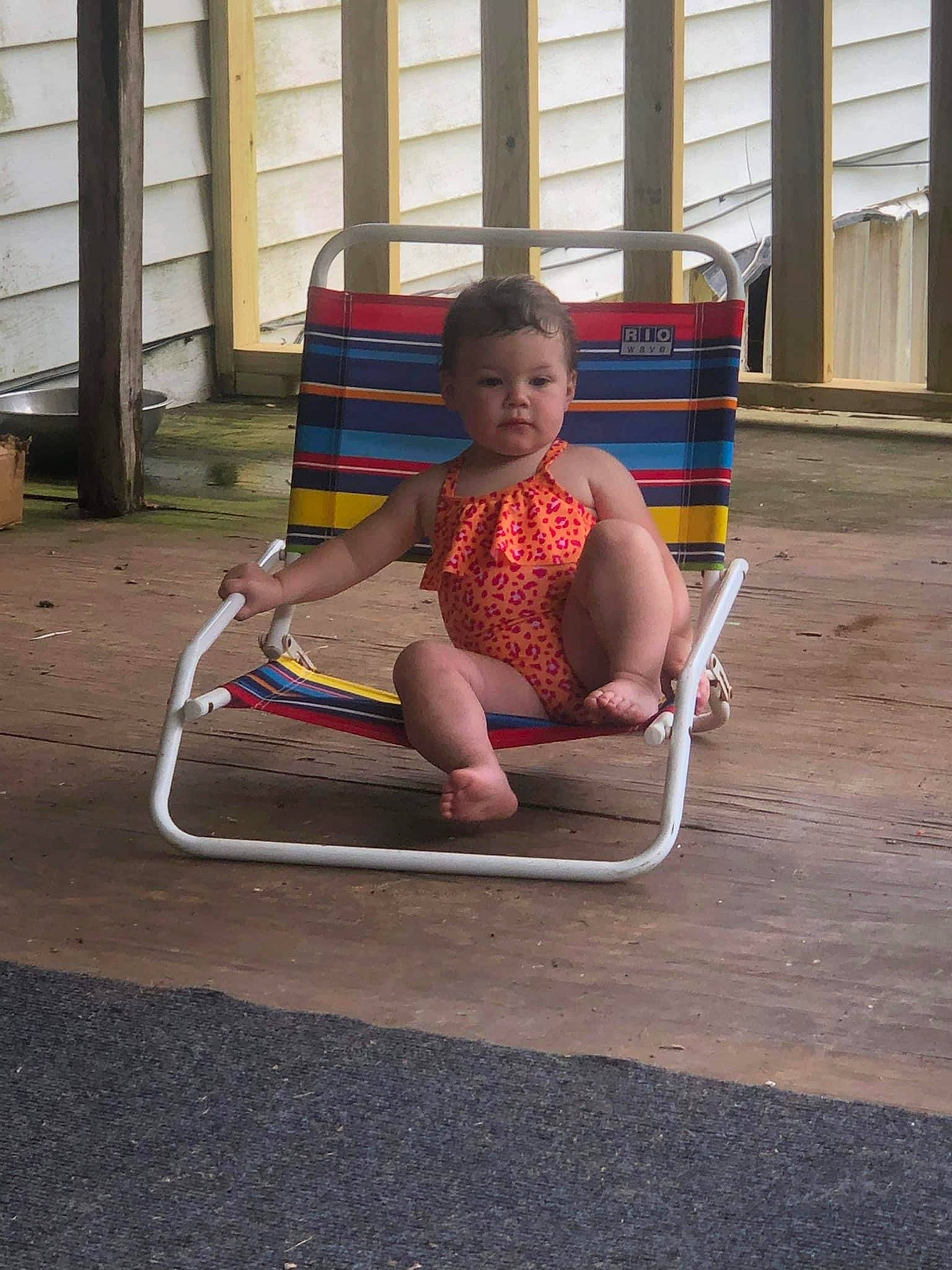 Isla is registered to the contest to win money with this photo: baby, baby_products, baby_toddler_clothing, barefoot, child, city, comfort, flooring, foot, fun, human_leg, leisure, outdoor_furniture, person, play, recreation, shade, sitting, toddler, window