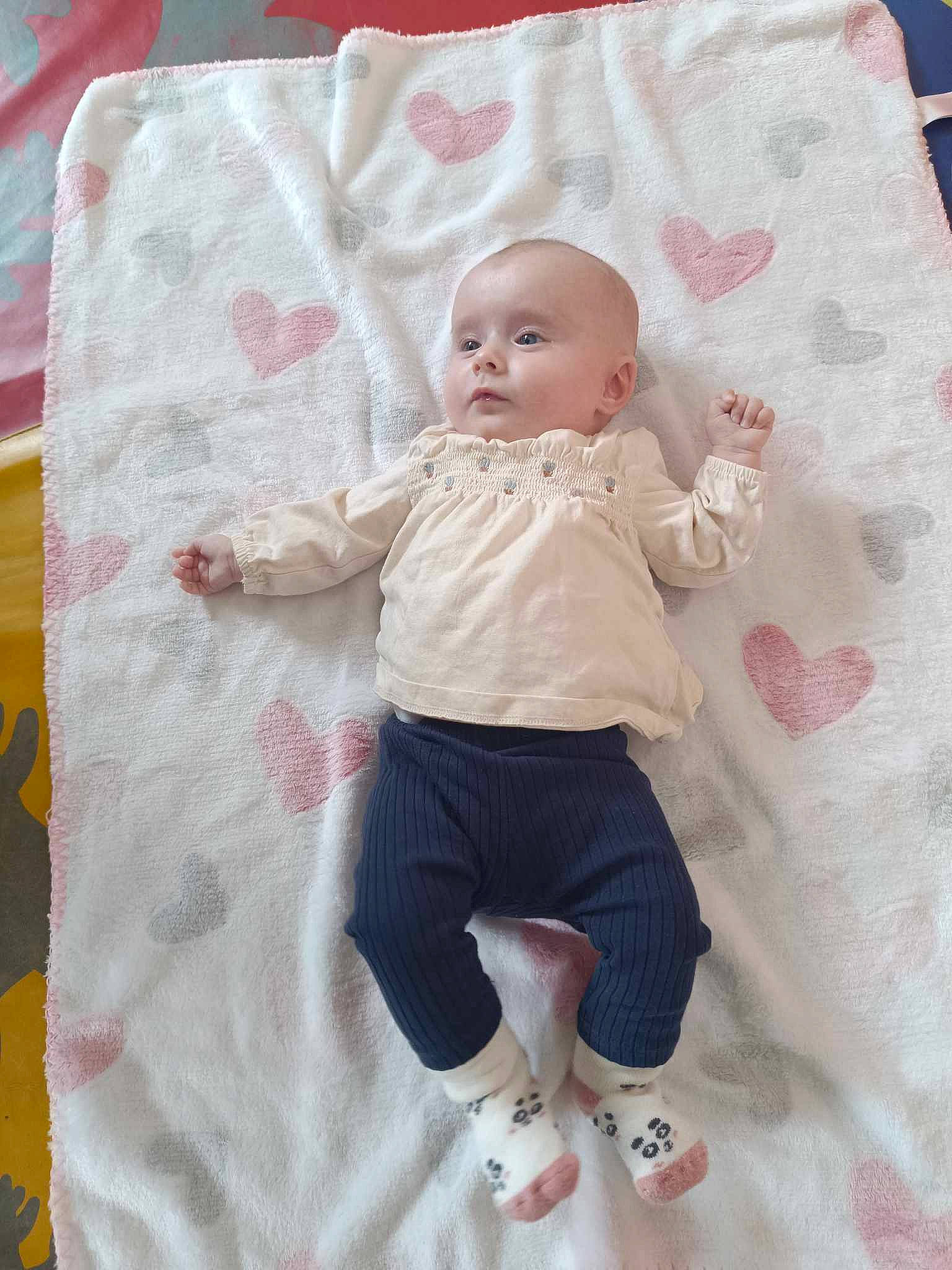 Nelya participe au concours pour gagner de l'argent avec cette photo : baby, baby_products, baby_toddler_clothing, cheek, child, comfort, face, happy, head, linens, magenta, pattern, person, pink, room, shorts, sitting, sleeve, t_shirt, textile