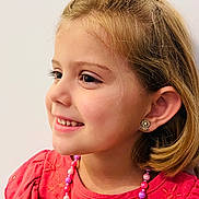 Lyla a rejoint le concours — aidez-le/la à gagner de superbes lots ! accessories, background, blonde_hair, casual, child, cute, earrings, fashion, girl, happy, indoor, jewelry, necklace, person, portrait, red_dress, side_profile, smile, young, youth