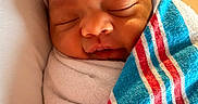 Goddess is registered to the contest to win money with this photo: newborn, baby, sleeping, blanket, hat, striped, hospital, swaddled, cute, peaceful, infant, closeup, face, head, soft, warm, child, portrait, resting, indoors
